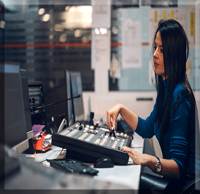 Show Control Development Design middle-aged-woman-using-equipment-in-control-room Mostly used in Theatrical environments