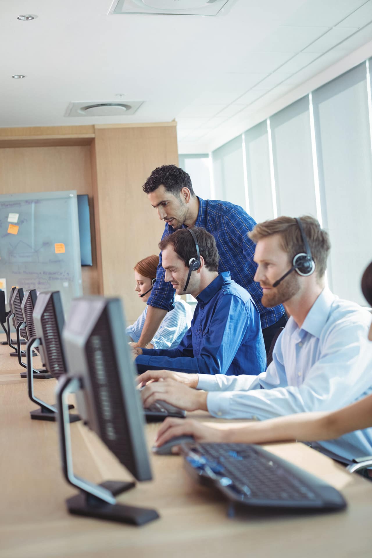 Male supervisor talking with event staff at Iconic HQ Event Management Call Center